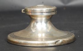 A silver hallmarked stub inkwell having engine turned lid, reeded peripheral borders to the base.