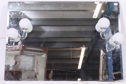 A large wall mounted 20th century decorated wall mirror with applied light sconces having frosted