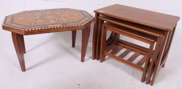 A retro 1970's teak Danish influence nest of tables raised on angular supports with graduating tops.