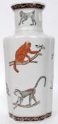 A white ground glazed Chinese vase of baluster form stylised with a diorama of monkeys, chimps etc.
