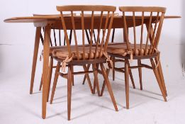 An Ercol blond beech and elm wood refectory dining table together with a set of 4 Ercol low