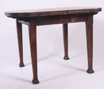 A n early 20th century draw leaf extendable table being raised on shaped legs with no central