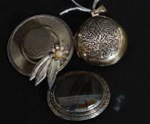 A collection of 3x silver / white metal brooches and lockets to include one in the form of a hat,