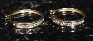 A pair of ladies 9ct gold and diamond earrings being channel set.