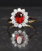 A 9ct hallmarked gold ring set with CZ and a central red gemstone. Weight 2.3g.