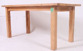 A 20th century pine refectory dining table raised on squared legs with planked top