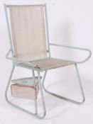 A 1950's shaped tubular metal childs chair, with rotating storage platforms to the base.