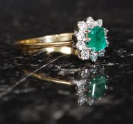 An 18ct gold and diamond ladies ring. The cushion cut emerald with diamond surrounds.