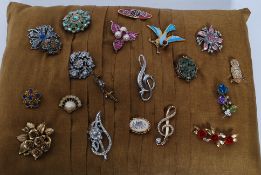 A collection of costume jewellery brooches, all mounted on a cushion,
