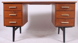 A 1970's teak wood retro desk raised on ebonised tapered legs with drawers to each pedestal having