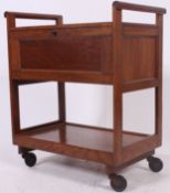 A mid century golden oak hostess trolley raised on castors with fall front sides and shaped handles