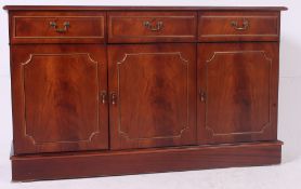 A 20th century antique style mahogany side cabinet raised on plinth base with drawers over