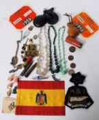 A collection of curios to include silver cuff links, enamel badges, glass and stone necklaces,