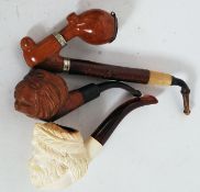 A collection of vintage pipes to include carved figural head,