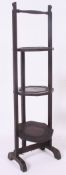 A 1930's metamorphic oak cake stand, with folding trays to centre and carry handle to top.