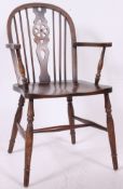 A 20th century Windsor wheelback armchair in beech having turned legs united by stretchers with