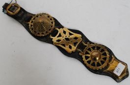 A Victorian leather strap set with brass shield and strap.