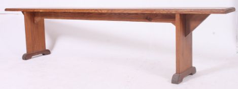 A 19th century French provincial pine refectory pig bench having a planked top with angled supports
