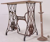 A vintage cast iron Singer sewing machine table, having a later top along with a wooden tadle lamp.