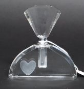 An art Deco style perfume bottle having an off set heart to the main body,