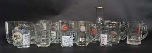 A collection of glass and pewter drinking ftankards to include advertising examples along with some