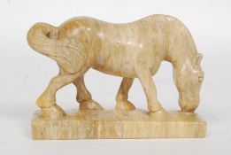 A 20th century carved agate / soapstone miniature figure of a grazing horse,