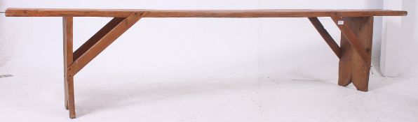 A 19th century French provincial pine refectory pig bench having a planked top with angled supports