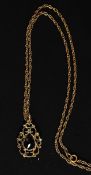 A 9ct gold necklace with a hallmarked rococo style pendant with central red garnet stone on a rope