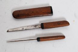 An unusual wood and horn mounted oriental eating set comprising knife and spike in scabbard.
