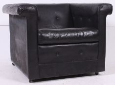 A  Le Corbusier LC2 style black leather armchair of square form with padded elbow rests raised on