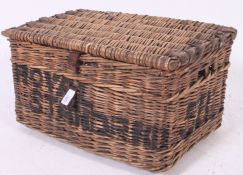 A vintage early 20th century whicker hamper / basket having animal hide straps  with notation to