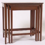 A retro vintage 1950's teak nest of tables raised on squared legs with graduating tops.