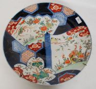 A very large 19th century Imari charger being decorated with geometric patterns having central