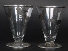 A pair of silver banded cut glass shot - liqueur glasses with silver banded rims and bases with