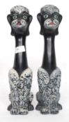A pair of mid-20th century kitsch long necked ceramic figures of dogs.
