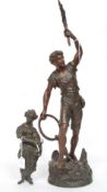 Two cast metal figures, man with raised torch along with a female of classical form.
