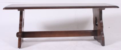 A 20th century Ercol dark oak colonial coffee table raised on lyre shaped supports with