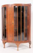 An early 20th century demi - lune display cabinet, having two glass lined doors,