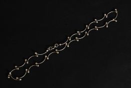 A pretty silver ladies shaped necklace with bow spacers and ball finials.