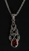 A silver marcasite and garnet pendant necklace. Total weight 4.0g.