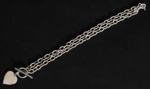 A chunky silver necklace with bar and hoop clasp having heart shaped pendant. Total weight 30g.