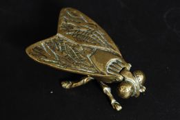 An early 20th century large brass table vesta case in the form of a fly with hinged top to wings