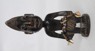 A Yoruba / Yorouba African tribal figure of softwood construction adorned with beads and shells