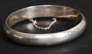 A traditional silver bracelet of hoop form with safety clasp. Stamped 925.
