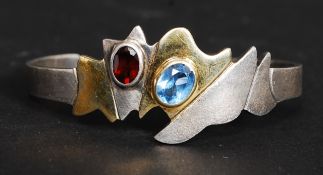 A contemporary ladies silver and gilded silver 925 marked bangle with inset ruby garnet stone and