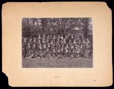A photograph of a group of 45 schoolgirls holding tennis racquets and hockey sticks printed by W.