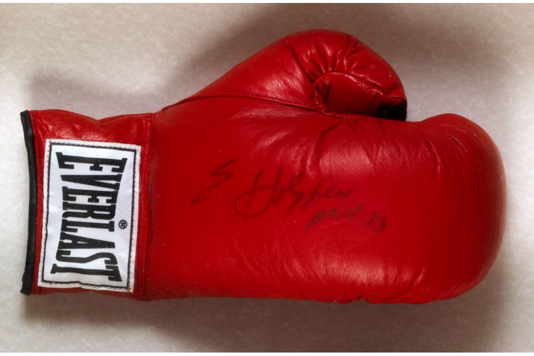 An Evander Holyfield signed boxing glove, a left-hand red Everlast glove signed in black marker pen,