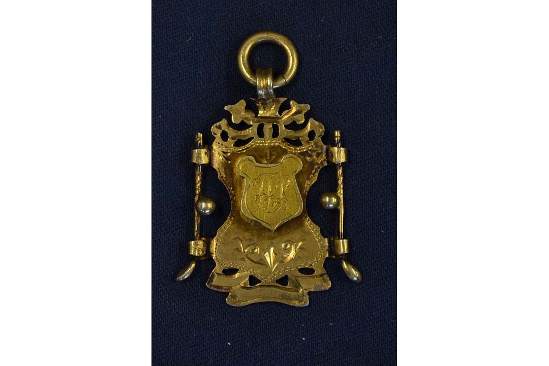 1896 silver gilt decorative golf medal - mounted with golf clubs^ balls and raised shield engraved