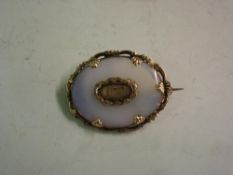 A Victorian Abalone and Yellow Metal Brooch Set with a lock of hair. (Loss to setting and cracked)