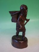 An Ethnic Carved Hardwood Figure A woman with a basket on her back and carrying a club. 11